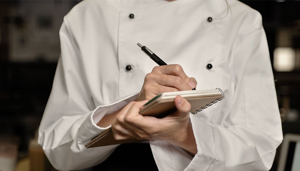 Image showcasing the service of menu curation by Signature Chef Cy. Culinary consultants are seen curating a menu, carefully selecting dishes that intricately tell a unique story through a variety of exquisite culinary offerings.